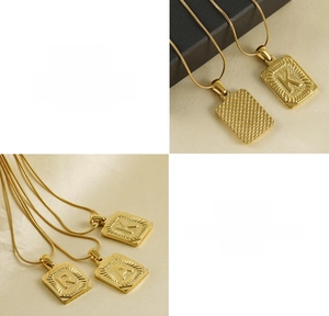 Détail de pendentifs lettres carrées en acier titane plaqué or 18K avec chaîne serpent