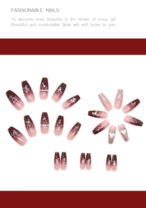 Close-up of long trapezoid fake nails with red gradient, silver glitter, and heart gems
