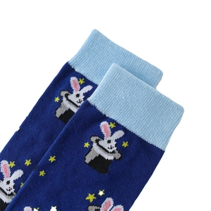 Detail of dark blue knit socks featuring a rabbit in a magic hat and yellow stars