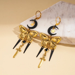 Metallic moon star and sword tassel hoop earrings on a decorative stone base