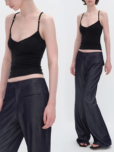 Top a canotta nera aderente con scollo a V abbinato a jeans blu a gamba larga alti