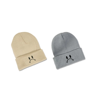 Bonnets en tricot minimalistes en beige et gris avec motif de visage triste brodé