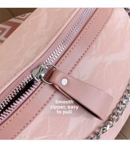 Detail of pink marble pattern bag with smooth silver zipper and metal chain strap