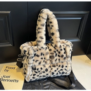 Detail of plush leopard print tote bag with soft texture and stylish black wide shoulder strap