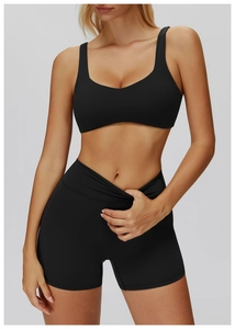 Close-up of black U-neck sports bra and high-waisted fitness shorts on model