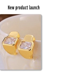 Detailed view of geometric square crystal earrings hanging on a white porcelain cup edge