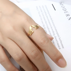 Detail of adjustable golden ring with two wolf head silhouettes on model's hand