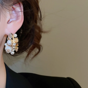 Close-up of floral pearl earrings with rhinestones worn by model for an elegant look