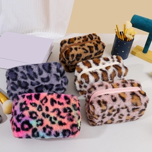 Flat lay of five colorful plush leopard print makeup bags with zipper closure and brushes