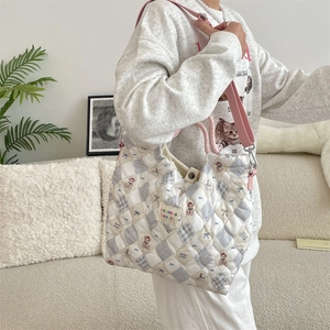 Sac cabas matelassé à motif d'ours avec bandoulière rose porté à l'épaule par un mannequin