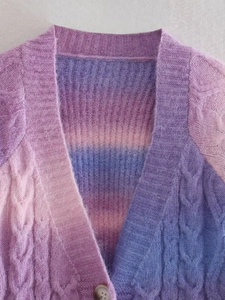 Detailed close-up of purple and blue tie-dye cable knit cardigan texture and buttons