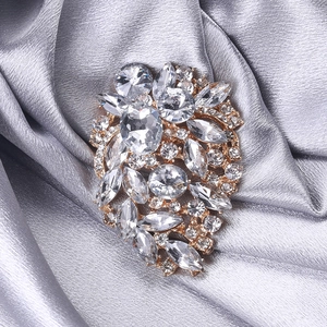 Macro shot of gold brooch with clear crystal rhinestones on a satin background