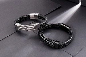 Dettaglio di bracciali in pelle intrecciata da uomo con chiusura magnetica in acciaio
