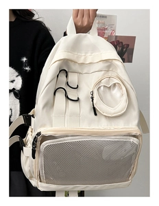 Close-up of a cream-white nylon backpack featuring a mesh pocket and heart-shaped window