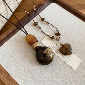 Collana vintage con pendente a cuore in occhio di tigre e perle dorate su legno