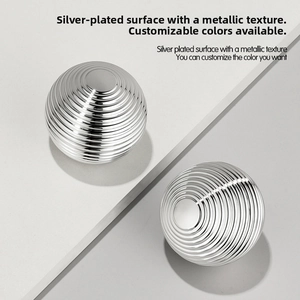 Close-up of silver-plated cosmetic jars with circular screw threads and metallic texture
