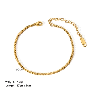 Detailed view of gold stainless steel box chain bracelet with lobster clasp and tag