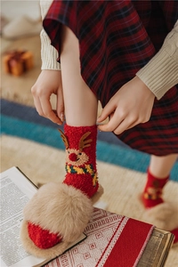 Detail of red Christmas reindeer socks made of warm coral fleece for winter comfort