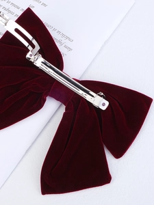 Close-up of the metal spring clip and premium burgundy velvet ribbon on the hair bow