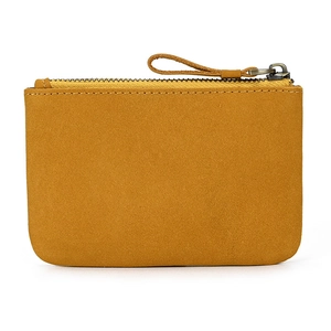 Close-up of yellow suede leather coin purse with zipper closure and smooth texture