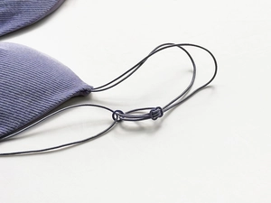 Detail of the purple ribbed knit fabric and delicate shoulder strap connector on bra