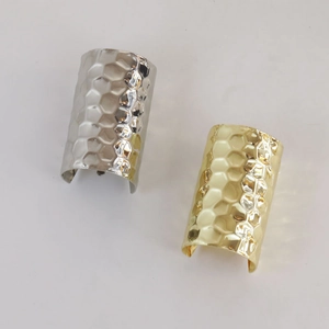 Detail von minimalistischen Armreifen mit Gold- und Silber-Wabenstruktur-Oberfläche