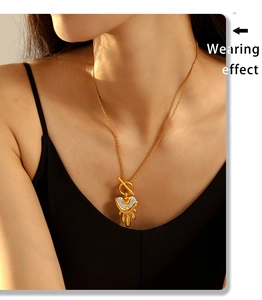 Detail of model wearing a gold melting heart pendant necklace with rhinestones and OT buckle
