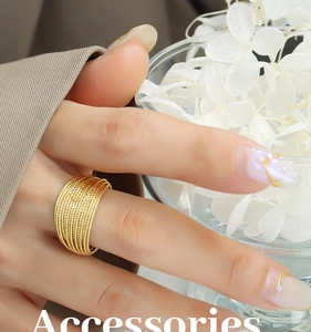 Close-up of gold layered wrap ring with multi-line woven texture on model hand