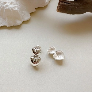 Detailed view of 925 sterling silver heart-shaped drop earrings on a minimalist background