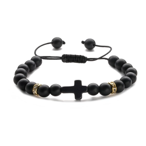 Detail of matte black beads bracelet with cross charm and gold rhinestone accents