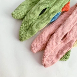 Close-up of cute knitted animal scarves in green and pink showing soft wool texture