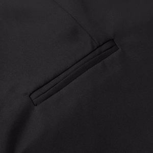Detailed close-up of a classic welt pocket on a black commuter-style blazer with neat stitching