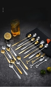 Makroaufnahme von Dessertlöffeln aus Edelstahl in Kirschblüten- und Rosenform in Gold