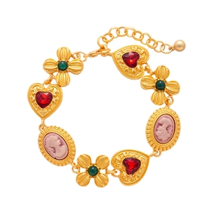 Vintage gold chain bracelet featuring red heart gems, flower patterns, and cameo charms