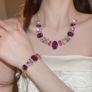 Close-up of vintage geometric necklace and bracelet set with pink and purple crystals
