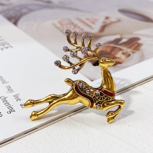 Detailed view of a golden reindeer brooch with crystal rhinestones and enamel accents