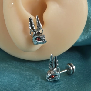 Détail des boucles d'oreilles lapin punk argenté avec yeux en pierres rouges sur oreille
