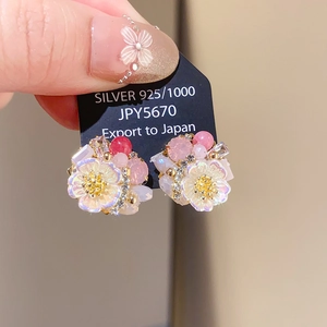 Detail of silver 925 bow-shaped earrings with pearls and crystals on price card