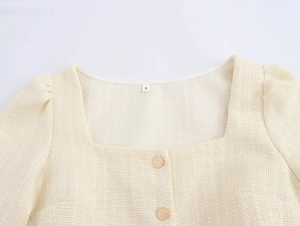 Gros plan d'une robe en tweed beige avec encolure carrée et manches bouffantes