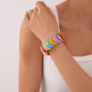 Detailed macro view of colorful acrylic geometric stretch bracelet with gold metal accents