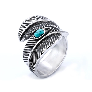 Vintage stainless steel open feather ring featuring a turquoise stone inlay on white background