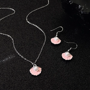 Detail of pink shell necklace and earrings set with pearl inlay and silver chain