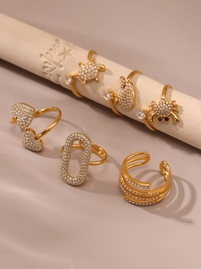 Dettaglio di anelli regolabili placcati oro con zirconi micro-pave e motivi animali