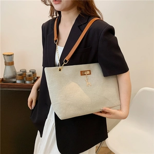 Minimalist canvas tote bag with brown leather straps and gold chain detail for women