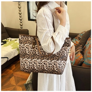 Détail d'un sac cabas imprimé léopard avec anses marron et rivets en décor intérieur