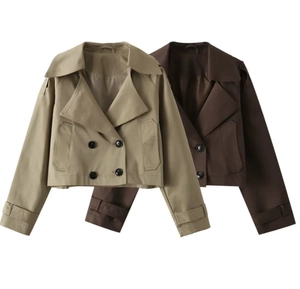 Detailed close-up of double-breasted cropped trench jacket with lapel collar and cuff straps