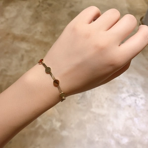 Close-up of gold titanium steel bracelet with solid circular charms on a woman wrist