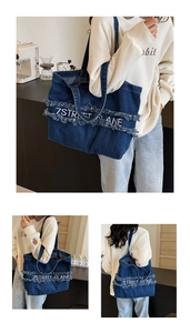 Détail du grand sac cabas en jean bleu avec broderie 7STREET LANE et bords effilochés
