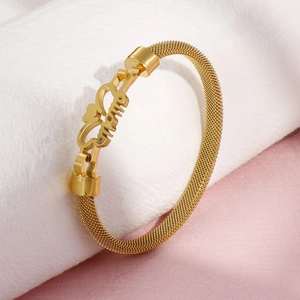 Golden mesh bracelet with MOM letters and heart design on a soft textured background