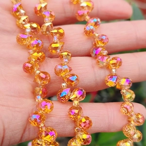 Macro detail of faceted orange gradient glass beads with sparkling light reflection
